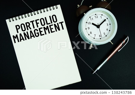 Portfolio Management text written on notepad with pen and alarm clock 138243786