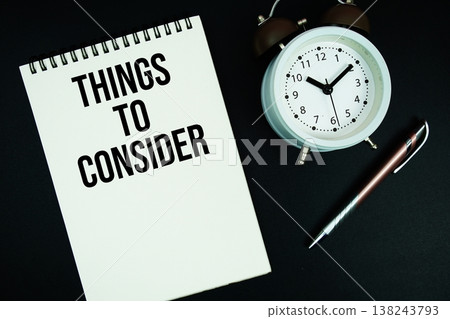 Things To Consider text written on notepad with pen and alarm clock Things To Consider text written on notepad with pen and alarm clock 138243793