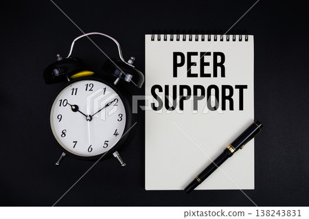 Peer Support text written on notepad with alarm clock top view on black background Peer Support text written on notepad with alarm clock top view on black background 138243831