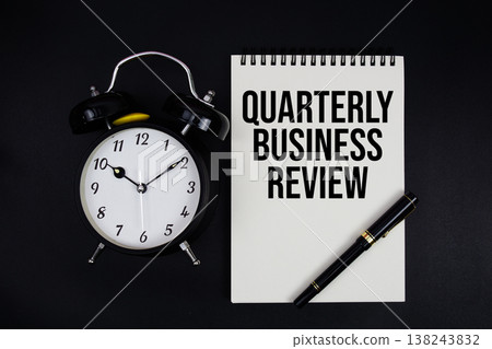 QBR Quarterly Business Review text written on notepad with alarm clock top view on black background QBR Quarterly Business Review text written on notepad with alarm clock top view on black background 138243832
