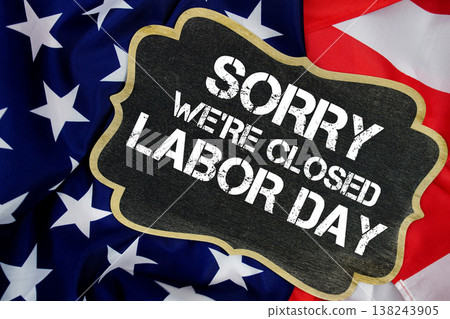Sorry We're Closed Labor Day written on blackboard with USA flag background Sorry We're Closed Labor Day written on blackboard with USA flag background 138243905