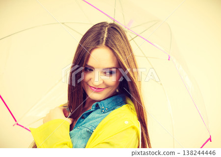 Woman wearing waterproof coat under umbrella Woman wearing waterproof coat under umbrella 138244446