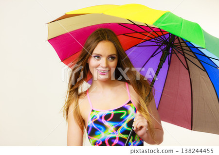 Happy woman posing in swimsuit and colorful umbrella 138244455