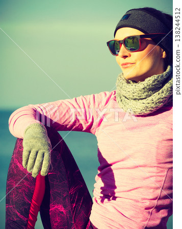 Woman resting after doing sports outdoors on cold day Woman resting after doing sports outdoors on cold day 138244512