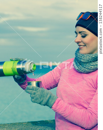 Fit woman in cold day warming up drink tea Fit woman in cold day warming up drink tea 138244517