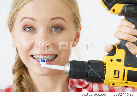 Woman burshing her teeth using drill Woman burshing her teeth using drill 138244585