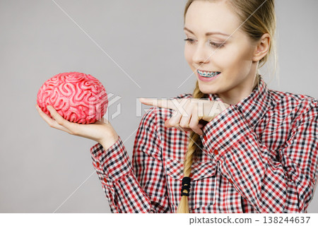 Woman thinking and holding fake brain Woman thinking and holding fake brain 138244637