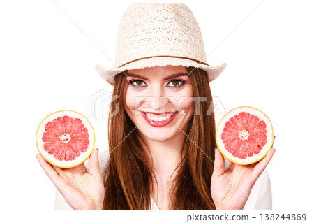 Woman holds two halfs of grapefruit citrus fruit in hands 138244869