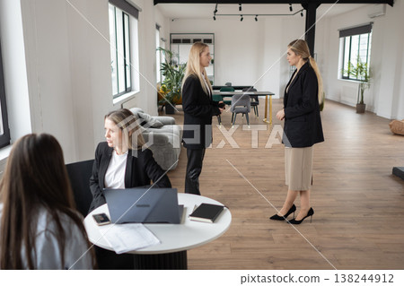 Two businesswomen collaborate over laptops in a bright, open plan office, sharing ideas and documents while discussing strategy, planning, and professional development Two businesswomen collaborate over laptops in a bright, open plan office, sharing ideas and documents while discussing strategy, planning, and professional development 138244912