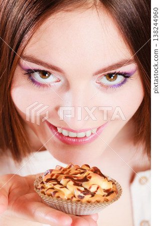 Smiling woman holds cake in hand Smiling woman holds cake in hand 138244960