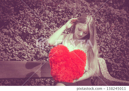 Disappointed woman with big red heart Disappointed woman with big red heart 138245011