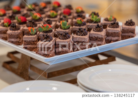 Many pieces of white cake and decorate by pink chocolate heart shape in buffet line. 138245117