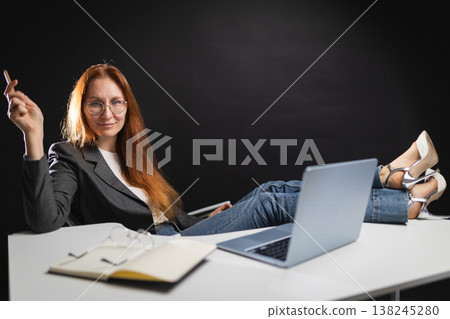 Confident businesswoman relaxing with feet on desk Confident businesswoman relaxing with feet on desk 138245280