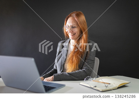 Professional woman working on laptop, smiling happily 138245286