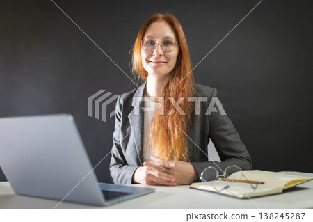Professional woman working at desk smiling at camera Professional woman working at desk smiling at camera 138245287