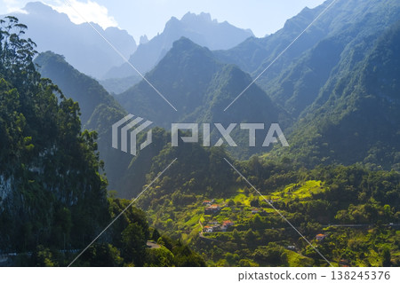 Funchal, Madeira lush mountains, showcasing terraced hills and vibrant greenery. Villages nestled in the valley create a peaceful, harmonious scene 138245376