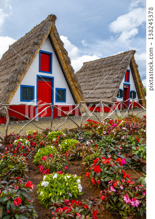 Traditional hut houses and garden of Madeira in village Santana. Sunny day in Portugal, tourist destination Traditional hut houses and garden of Madeira in village Santana. Sunny day in Portugal, tourist destination 138245378
