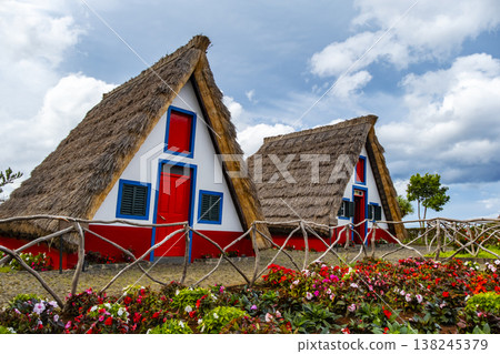 Traditional hut houses and garden of Madeira in village Santana. Sunny day in Portugal, tourist destination Traditional hut houses and garden of Madeira in village Santana. Sunny day in Portugal, tourist destination 138245379