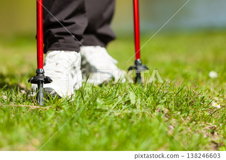 Nordic walking. Female legs hiking in the park. Nordic walking. Female legs hiking in the park. 138246603