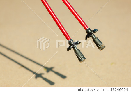 Nordic walking. Red sticks on the sandy beach 138246604