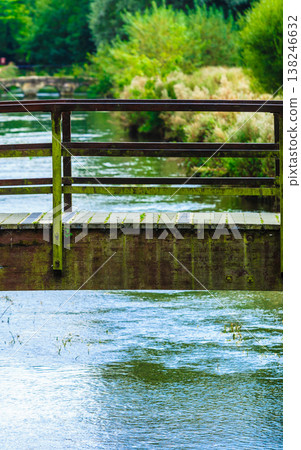 Old small bridge over river in green garden. Old small bridge over river in green garden. 138246632