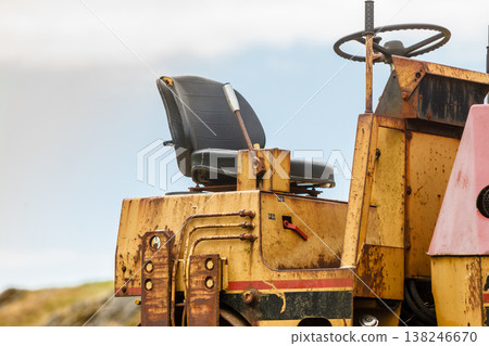 Combine harvester standing next to coutryside path 138246670
