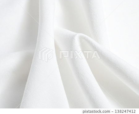 A close-up of soft white cotton fabric characterized by its pleats and clean appearance. 138247412