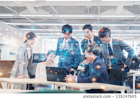 辦公室裡，人們一邊看著電腦一邊進行團隊討論。 138247605