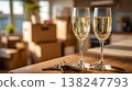 Two champagne glasses on wooden table with keys, moving boxes in new apartment background 138247793