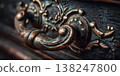 Ornate vintage drawer handle with intricate design on dark wooden surface close-up 138247800