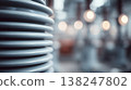 Ceramic electrical insulator with coiled design in industrial setting, blurred background lights 138247802