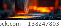 Industrial furnace nozzle with molten metal and glowing forge in steel mill environment 138247803