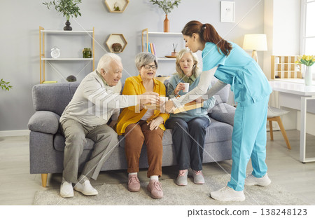 Caring nurse serving tea to smiling seniors, enjoying warm drinks and friendly conversation. Caring nurse serving tea to smiling seniors, enjoying warm drinks and friendly conversation. 138248123