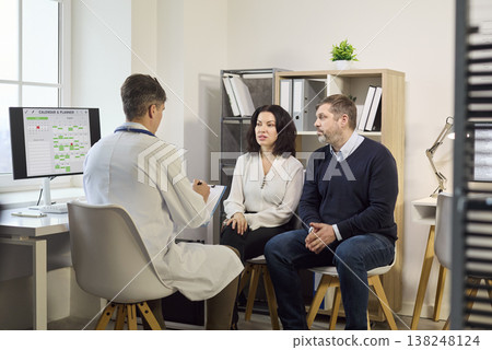 Couple receiving fertility and pregnancy planning consult with doctor in clinic Couple receiving fertility and pregnancy planning consult with doctor in clinic 138248124