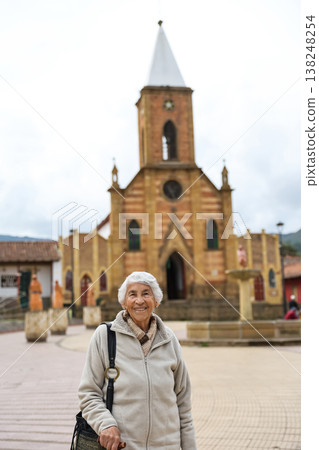 Happy senior lifestyle concept. Senior woman at the central square of the beautiful small town of Raquira. The city of pots in Colombia. 138248254