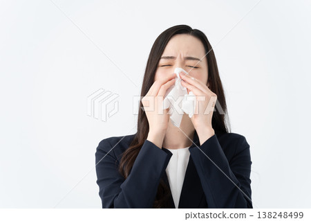 一位患有花粉症的女士用紙巾擦拭流鼻涕。 138248499