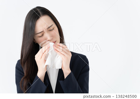 一位患有花粉症的女士用紙巾擦拭流鼻涕。 138248500