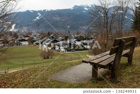 Wooden bench overlooking village and mountain slope in Bavaria 138249931