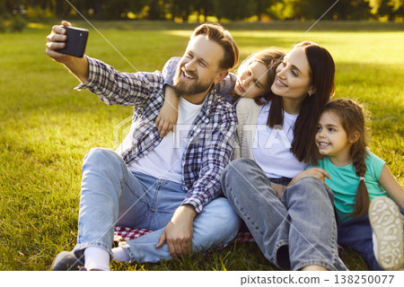 Family with kids spending time together making photo on mobile phone camera in summer park Family with kids spending time together making photo on mobile phone camera in summer park 138250077