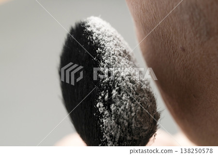 A woman's hands applying makeup; her hands applying powder. A woman's hands applying makeup; her hands applying powder. 138250578
