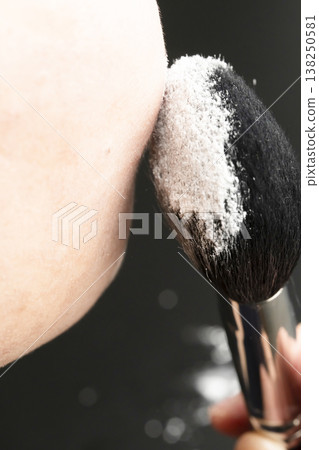 A woman's hands applying makeup; her hands applying powder. A woman's hands applying makeup; her hands applying powder. 138250581