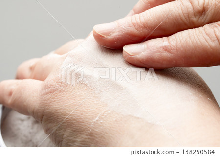 A woman's hands applying makeup; her hands applying powder. A woman's hands applying makeup; her hands applying powder. 138250584