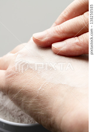 A woman's hands applying makeup; her hands applying powder. 138250585