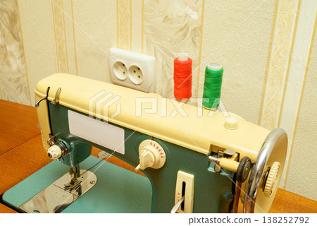 top view of a sewing machine body with installed spools of red and green threads top view of a sewing machine body with installed spools of red and green threads 138252792