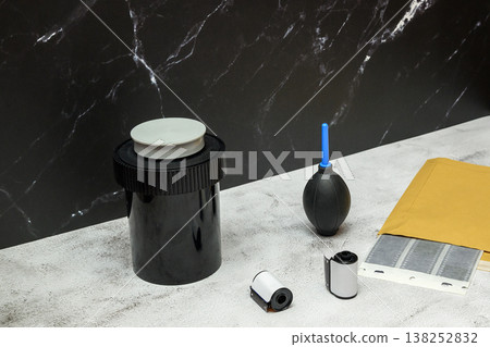 developing tank and accessories for a photographer on a light table near a dark wall developing tank and accessories for a photographer on a light table near a dark wall 138252832