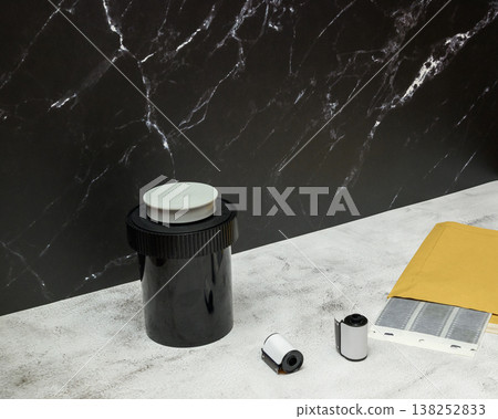 composition with a developing tank and an envelope for negatives on a gray background in a studio composition with a developing tank and an envelope for negatives on a gray background in a studio 138252833