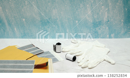 protective gloves and photographic film on a white table against a blue wall background in a lab protective gloves and photographic film on a white table against a blue wall background in a lab 138252834