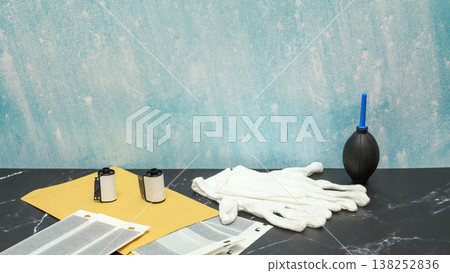 set for photographic archive design with negatives and gloves on a dark table in an interior set for photographic archive design with negatives and gloves on a dark table in an interior 138252836