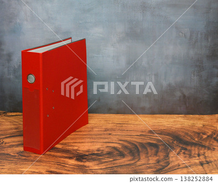 single red folder for documents on table near wall 138252884