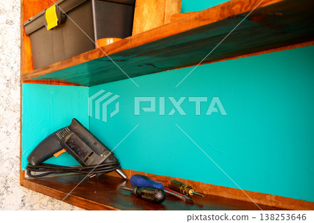 drill and screwdrivers on a workshop shelf close up drill and screwdrivers on a workshop shelf close up 138253646